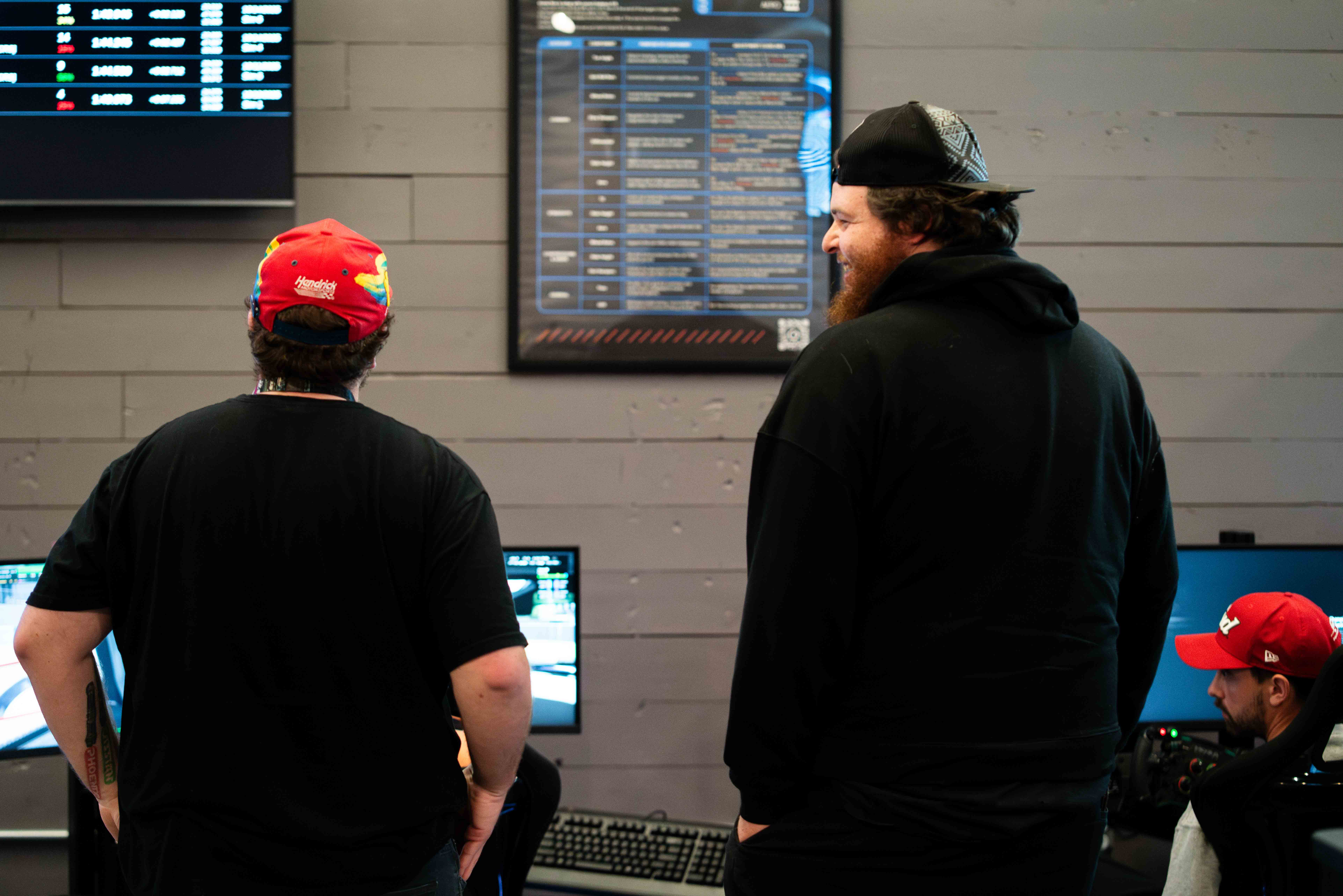 Staff and customers looking at a race leaderboard display